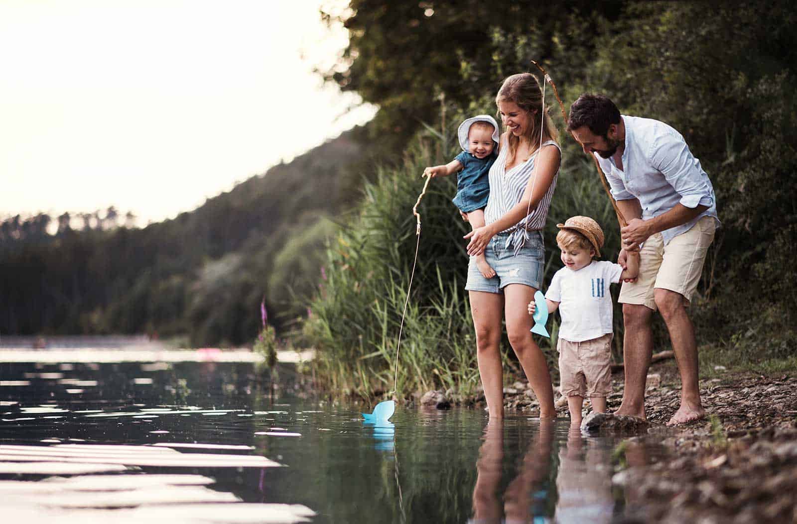 a family standing in water with a fishing rod