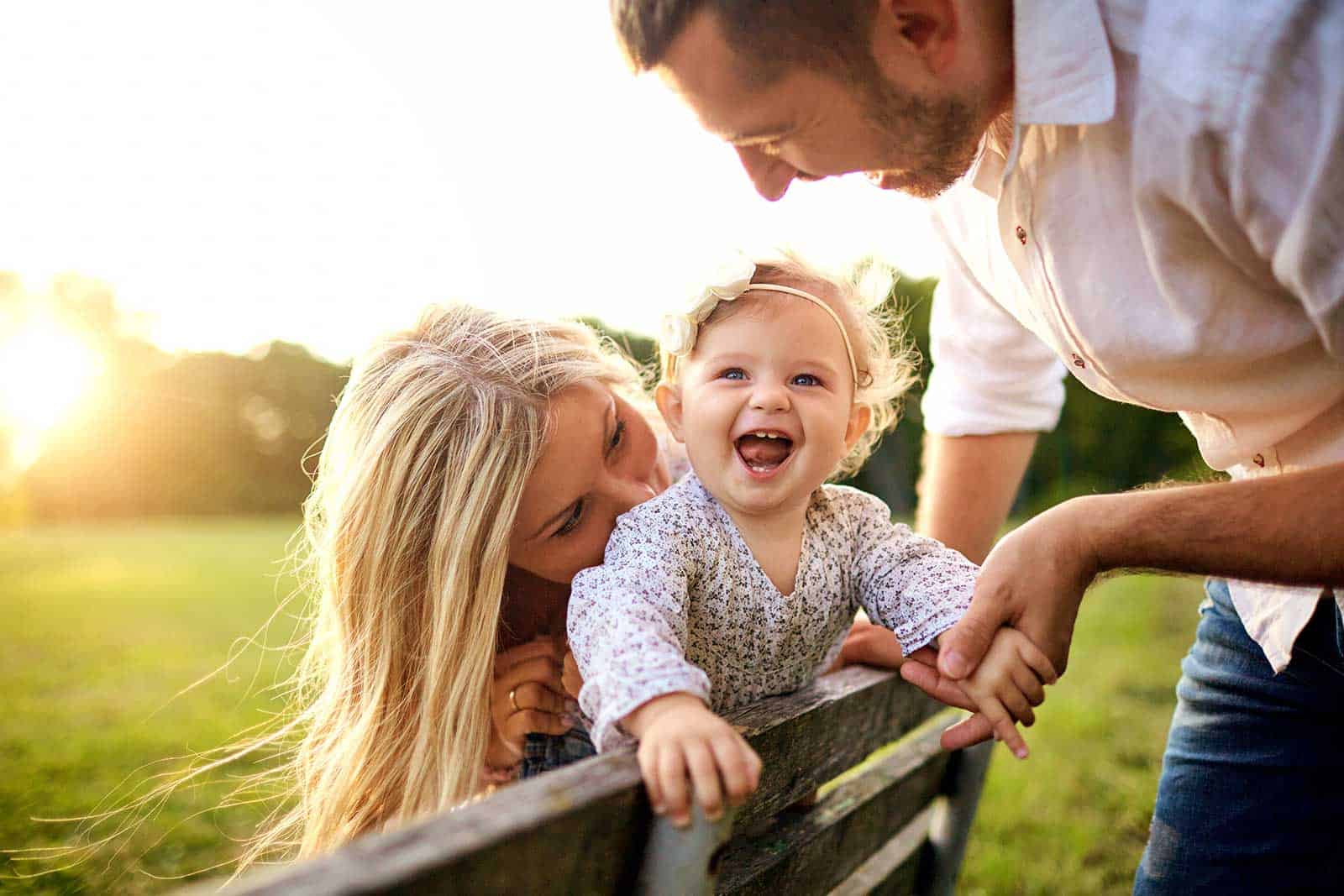 a man and woman with a baby on a bench