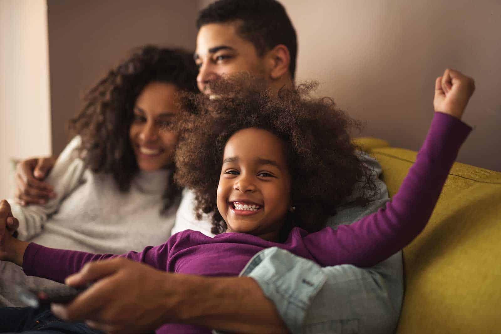 a man and woman sitting on a couch with a child