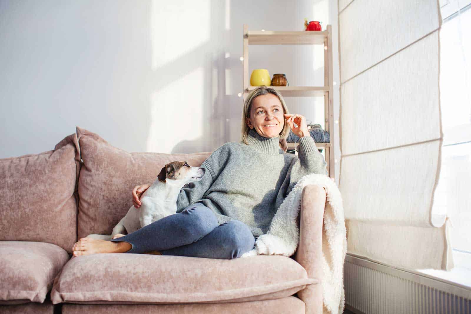 a woman sitting on a couch with a dog