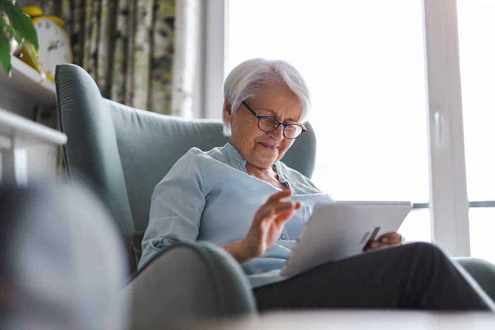 woman looking at a tablet - Marion Dentures