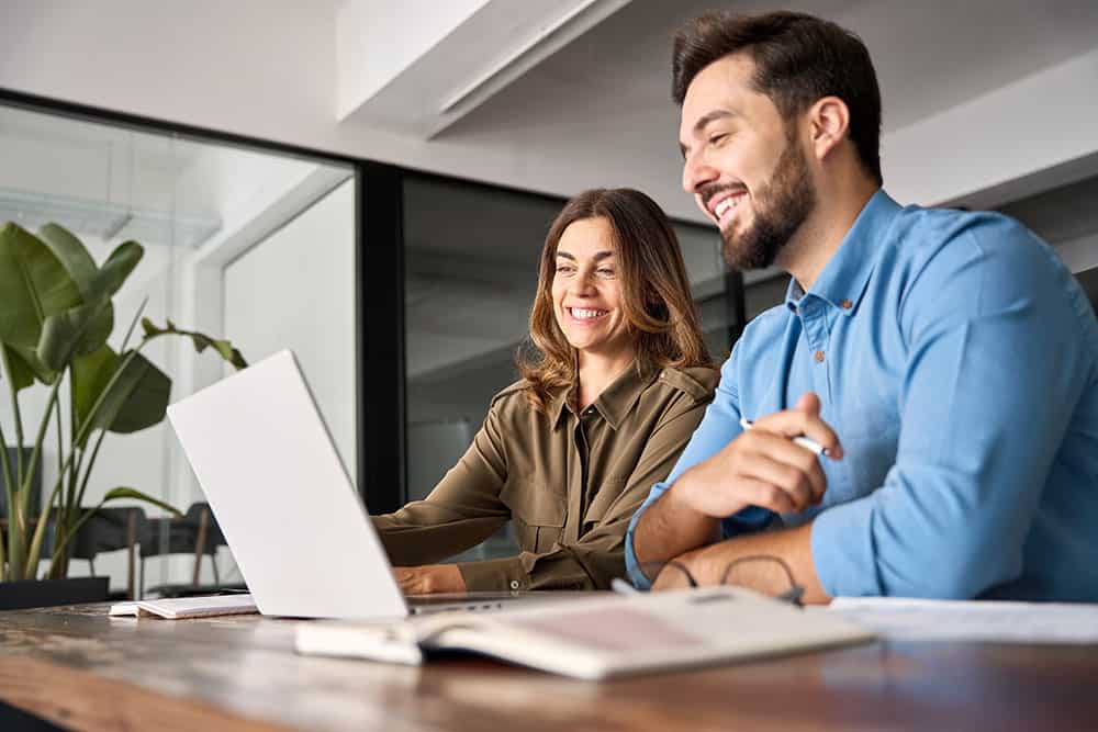 a man and woman looking at a laptop